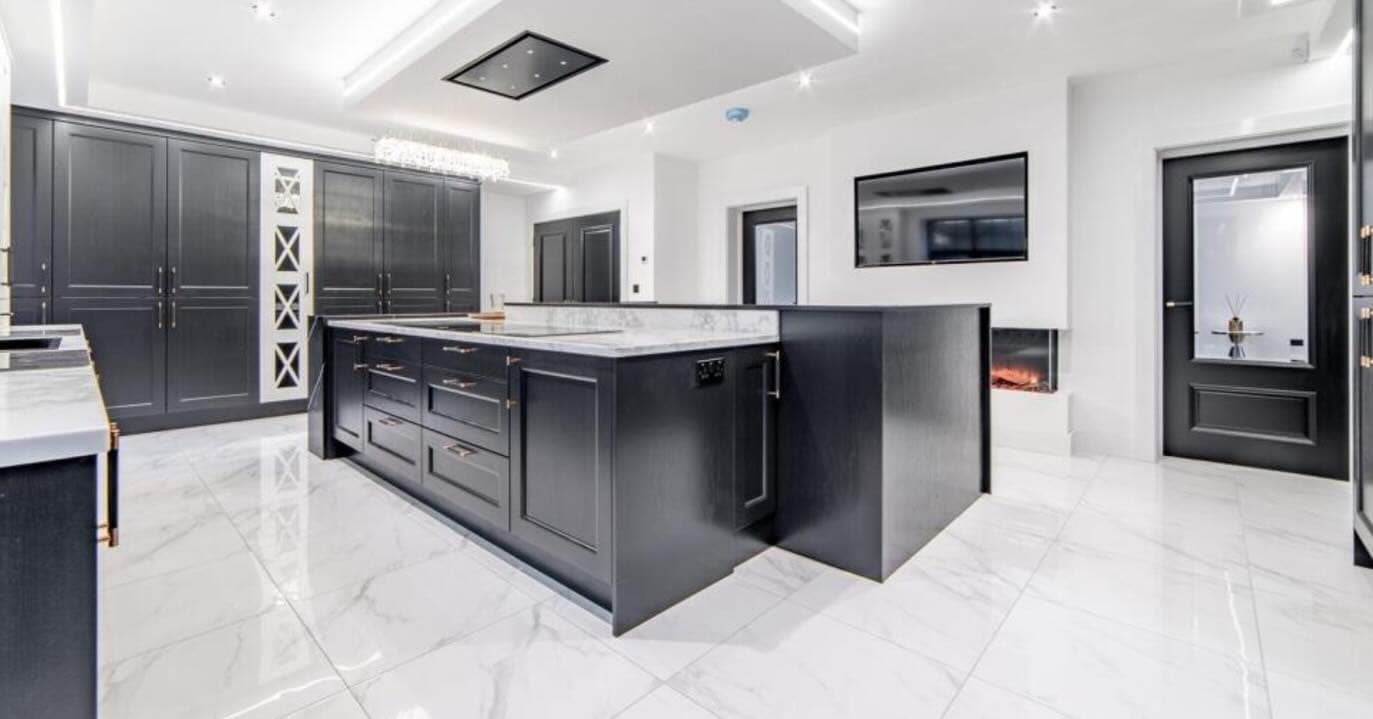 Modern black and white kitchen with marble island and gold hardware